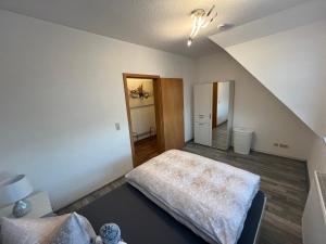 an attic room with a bed and a staircase at Ferienwohnung Mittweida-City "Schacherhaus" - direkt im Stadtzentrum der Hochschulstadt Mittweida in Mittweida