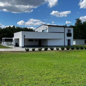 a large white building with a green field in front at Otfa 47 Kiskunmajsa in Kiskunmajsa