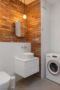 a bathroom with a sink and a washing machine at Mint&Lemon Old Town in Krakow