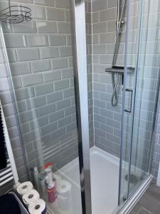 a bathroom with a shower with blue tiles at Chesil Beach View in Fortuneswell