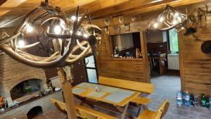a dining room with a table and a fireplace at Cabana cu trofee in Schitu-Tarcău