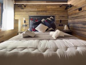 莫埃纳Duo Charme的卧室配有一张白色大床和木墙