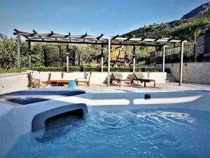 una piscina d'acqua in un cortile con un pergolato di Countryside Retreat Villa with Pool,Jaccuzi a Klis