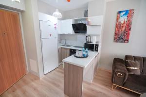 a small kitchen with a white refrigerator and a table at Classic Suite TS32 in Esenyurt +12 photos
