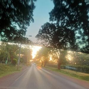 eine leere Straße mit Sonnenuntergang in der Ferne in der Unterkunft Eldorado cabin in Nyeri
