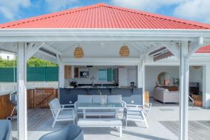 un pabellón con techo rojo en un patio en Villa Paloma, en Grand-Bourg