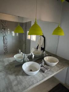 a bathroom with three sinks and three lights at Big Cats Namibia Farmstays in Outjo