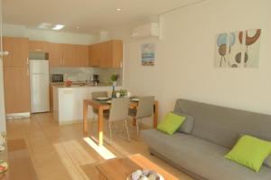 un salon avec un canapé et une table et une cuisine dans l'établissement Apto Liss 50 metros de la playa, à Lloret de Mar