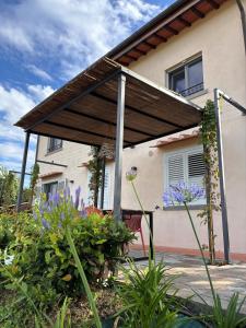 a wooden pergola on the side of a house at Eri tra gli Ulivi in Gropina
