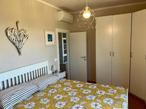 a bedroom with a bed with a yellow and white blanket at Eri tra gli Ulivi in Gropina