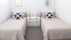 Habitación con 2 camas individuales y paredes blancas. en Sawtell Sunrise, en Sawtell