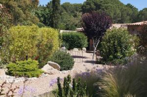 a garden with bushes and trees and a house at Les Jardins De Santa Giulia - Charmante chambre dhte in Porto-Vecchio +7 photos