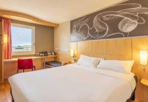 a hotel room with a large bed and a window at B&B HOTEL Marseille Bonneveine in Marseille