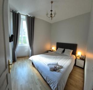 a bedroom with a bed with two towels on it at St Nectaire- Appartement Terrasse Privée- 4 personnes in Saint-Nectaire