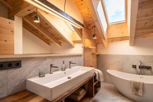 a bathroom with a large white sink and a tub at Großplonerhof in Luson