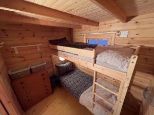 a bedroom in a log cabin with two bunk beds at Nordlands hytta in Meby