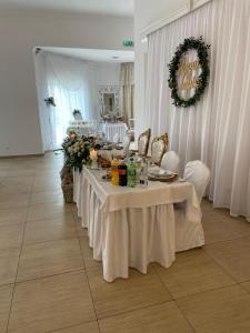 a table with white table cloths and flowers on it at Marysienka in Bisztynek