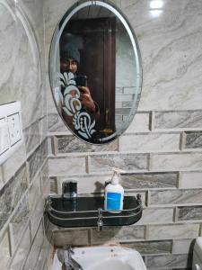 a man taking a picture of a mirror in a bathroom at Shraddhalu Niwas in Prayagraj +7 photos