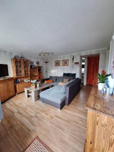 Haus-J-Bull-das-Sonneneck-Ferienwohnung-an-der-schoenen-Ostsee-in-Boergerende-Rethwisch في بورغيريندي-ريثفيش: غرفة معيشة بها أريكة وطاولة