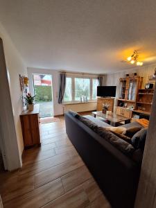 Haus-J-Bull-das-Sonneneck-Ferienwohnung-an-der-schoenen-Ostsee-in-Boergerende-Rethwisch في بورغيريندي-ريثفيش: غرفة معيشة بها أريكة وطاولة