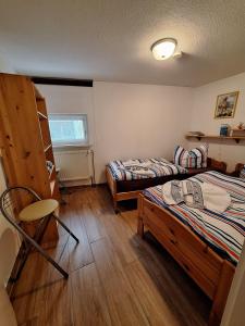 Haus-J-Bull-das-Sonneneck-Ferienwohnung-an-der-schoenen-Ostsee-in-Boergerende-Rethwisch في بورغيريندي-ريثفيش: غرفه سريرين وكرسي فيها +4 صور