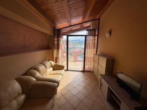 a living room with a couch and a tv and a window at Casa di mare - Portorosa in Furnari