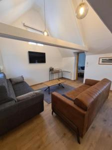 a living room with a couch and a tv at cottages de la Maye in Rue