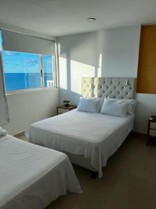a bedroom with two beds and a large window at Excelente vista in Cartagena de Indias
