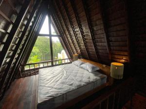 a bed in a room with a large window at Wira's TB Villas, One Bedroom Wooden Pool Villa in Kapal