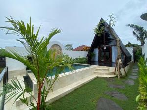 a villa with a swimming pool and a house at Wira's TB Villas, One Bedroom Wooden Pool Villa in Kapal +18 photos
