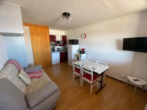 ein Wohnzimmer mit Couch und Tisch und eine Küche in der Unterkunft Appartement face aux montagnes - Belle étoile in Eyne