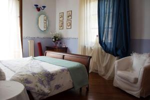 a bedroom with a bed and a chair and a window at Il Campano in Collodi