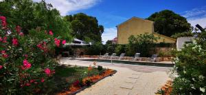 a swimming pool with chairs and flowers in a yard at 1 Eti And Mia House in Muntić