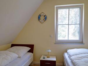 グロヴェにあるUrlaub Mit Hund Im Bernsteinhusの窓のある部屋にツインベッドが2台