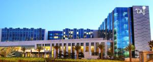 a tall building with palm trees in front of it at Taj Bangalore in Devanahalli-Bangalore