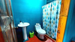 a blue bathroom with a sink and a toilet at Rustico Villa Arenal in Fortuna