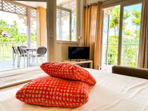 two red pillows sitting on a bed in a bedroom at Maison Créole in Saint-François +28 photos
