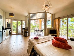 a large bedroom with a large bed and a kitchen at Maison Créole in Saint-François