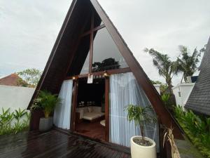 a house with a triangular roof with a window at Wira's TB Villas, One Bedroom Wooden Pool Villa in Kapal