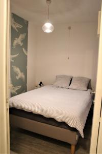 a bedroom with a bed with white sheets at Cosy gezellig app met aparte gastenkamer op 30meter van strand privé garage in Koksijde
