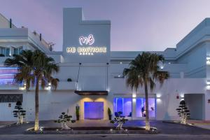 a building with palm trees in front of it at MB Boutique Hotel - Adults Recommended in Nerja