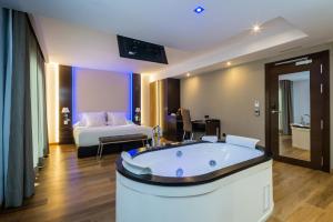 a hotel room with a bath tub and a bed at MB Boutique Hotel - Adults Recommended in Nerja