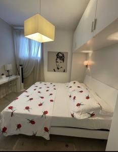 a bedroom with a bed with red flowers on it at Bellissimo appartamento frontemare con terrazza in Caorle