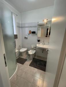 a bathroom with a sink and a toilet and a shower at Bellissimo appartamento frontemare con terrazza in Caorle