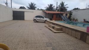 une voiture garée dans un parking à côté d'une maison dans l'établissement casa do fred enseada, à Guarujá