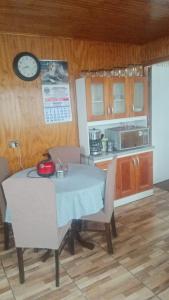 a kitchen with a table with chairs and a clock on the wall at Casa in Castro