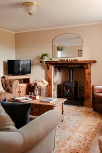 ein Wohnzimmer mit Couch und Kamin in der Unterkunft Park Cottage - Seasgair Lodges in Kingussie + 8 Fotos