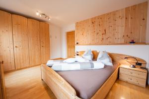 a bedroom with a large bed with wooden cabinets at Ferienwohnungen Kalchgruberhof in Ultimo
