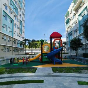 a playground in front of a building with a slide at Gallardo Homestay at Marina Spatial Condo in Dumaguete