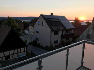 a view from a balcony of a house with the sunset at Ferienwohnung Seeblick in Pleinfeld